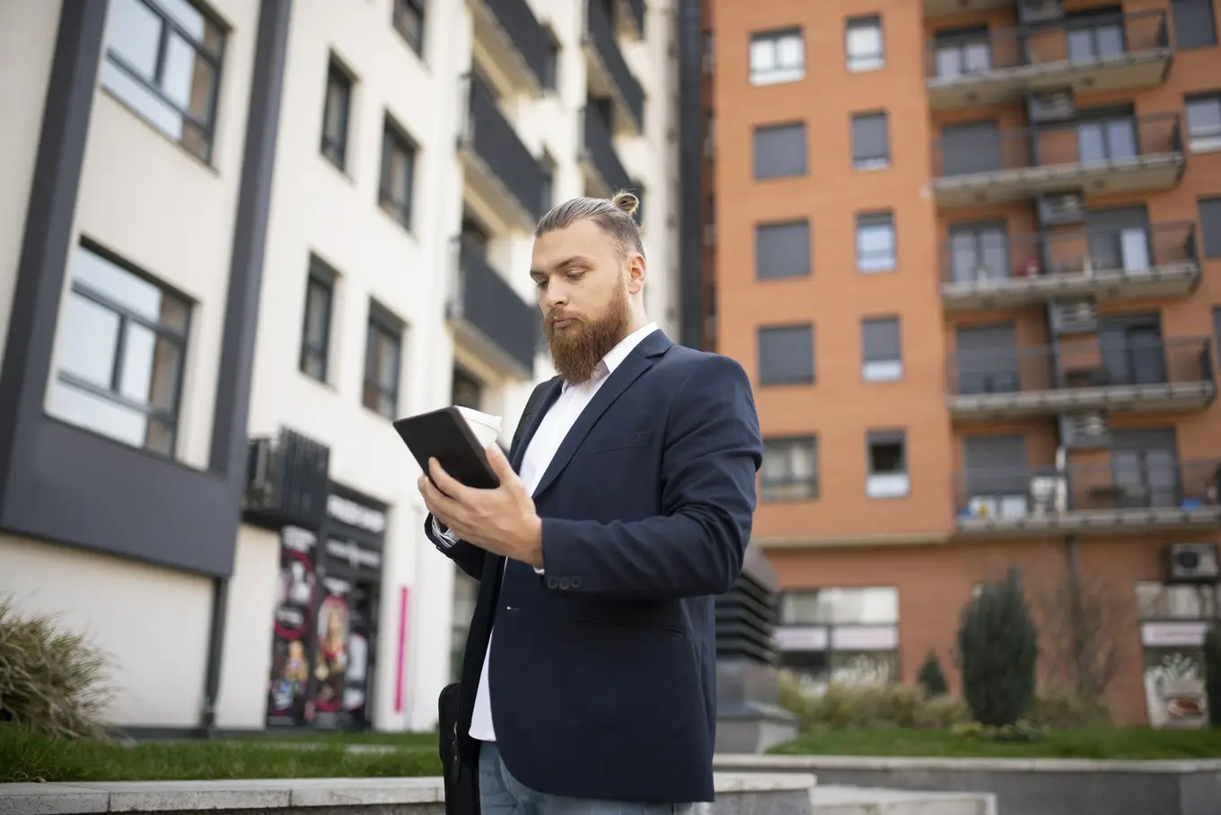 mężczyzna z tabletem na osiedlu